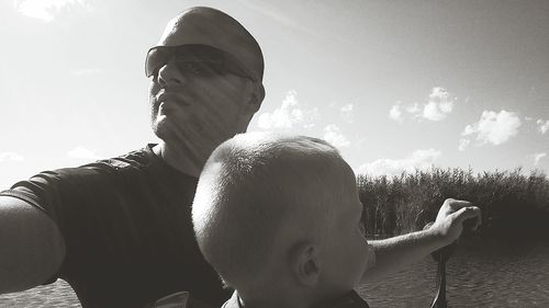 Portrait of father with son against sky