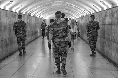 Rear view of people walking on subway station