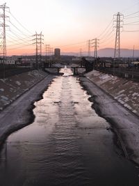 Bridge over river against sky during sunset