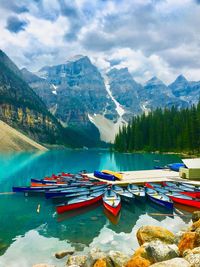 Boats moored on lake against mountains