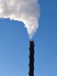 Low angle view of smoke emitting from chimney against sky