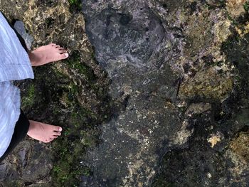 Low section of man standing on rock