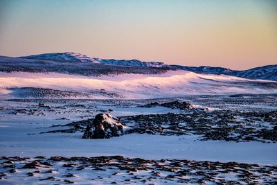 Scenic view of snow covered mountains against sky during sunset