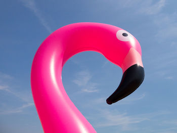 Low angle view of pink umbrella against swimming pool