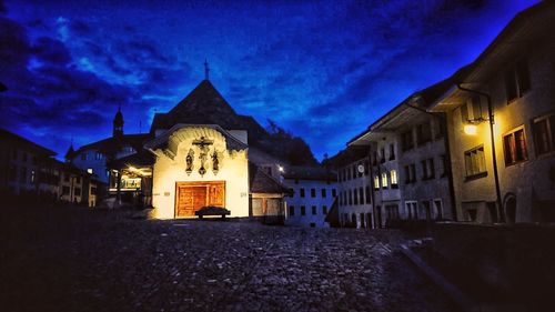 Illuminated buildings against sky at dusk