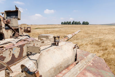 Abandoned truck on field against sky