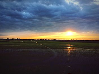 Scenic view of agricultural field against dramatic sky