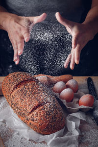 Baker's man spraying flour on bread and eggs