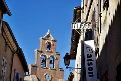 Low angle view of buildings against clear blue sky