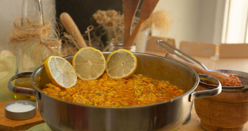 Seafood paella with lemon on kitchen table