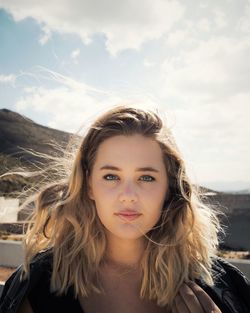 Portrait of a beautiful young woman against sky