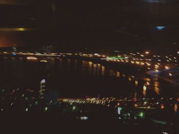 Illuminated bridge over river at night