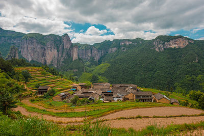 Scenic view of agricultural field and houses against sky