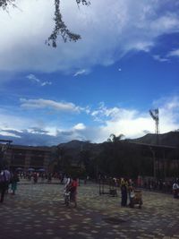 People on mountain against cloudy sky