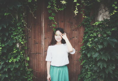 Portrait of woman standing by plants