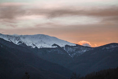 Scenic view of snowcapped mountains against sky during sunset