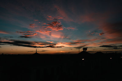 Silhouette buildings against sky during sunset