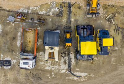 Amazing aerial view of asphalt spreading machines and truck at a construction site. 