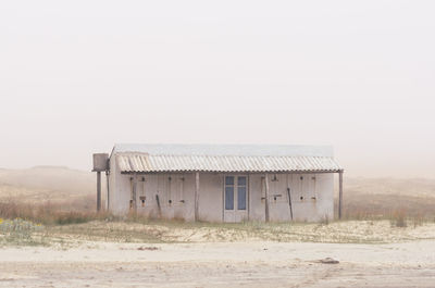 Abandoned building on field against clear sky