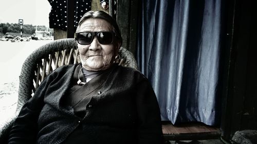 Portrait of senior woman wearing sunglasses sitting on chair