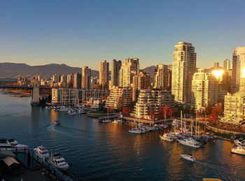 Panoramic view of bay and buildings against clear sky