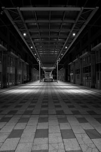 Empty corridor in illuminated building at night