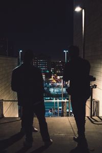 Man standing on illuminated street at night