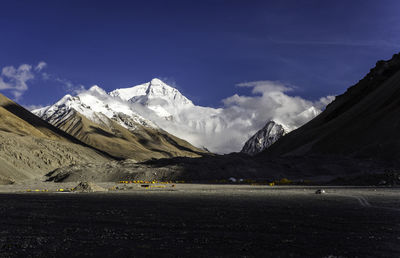 Scenic view of landscape and mountains against blue sky