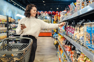 Portrait of young woman standing at supermarket