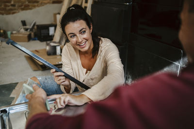 Happy woman discussing with man while renovating home