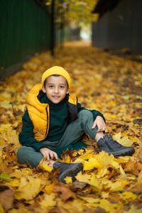 Portrait of smiling young woman sitting on field