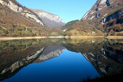 Scenic view of lake and mountains against blue sky