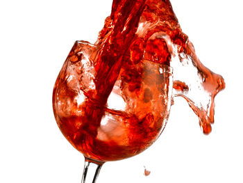 Close-up of red wine in glass against white background