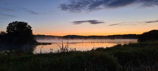 Scenic view of lake against sky during sunset