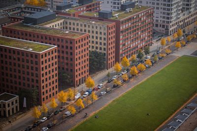 High angle view of cars by buildings in city during autumn