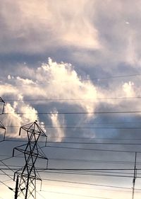 Low angle view of power lines against cloudy sky