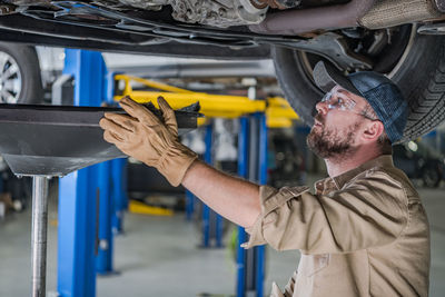 Mechanic repairing car at garage