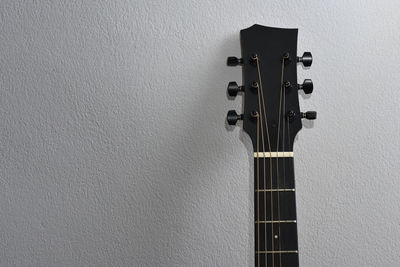 Close-up of guitar against wall