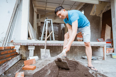 Side view of young man working at construction site