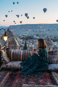 Woman sitting on seat against sky