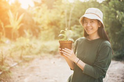 Portrait of smiling young woman standing on land