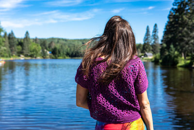 Midsection of woman standing on lake against sky