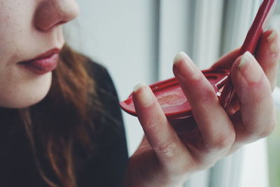 Cropped image of woman holding hand mirror
