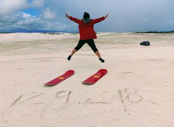 Full length of boy on beach against sky