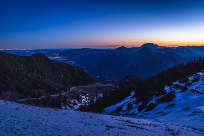 Scenic view of snowcapped mountains against sky during sunset