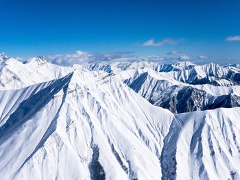 Scenic view of snowcapped mountains against blue sky