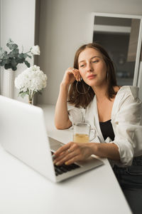 Businesswoman using laptop at table