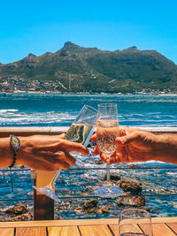 Close-up of wine glass against calm sea