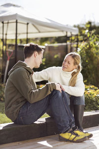 Mother and son talking while sitting in garden