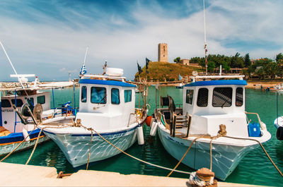 Boats moored on shore against sky